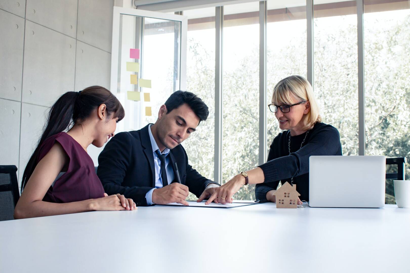 Husband and wife consult with the owner on the contract of house sale.