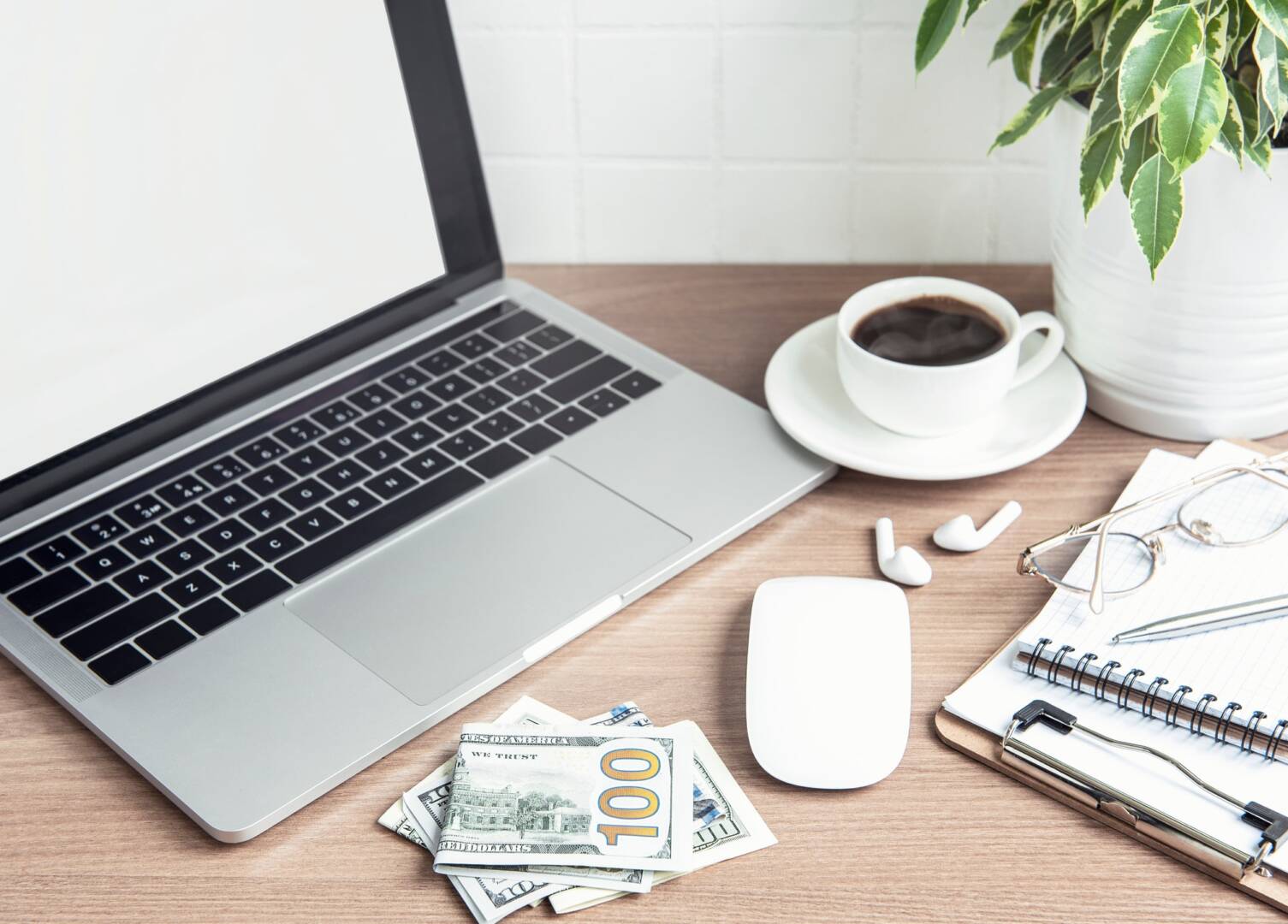 Office desktop. Laptop with office supplies and money on the table.